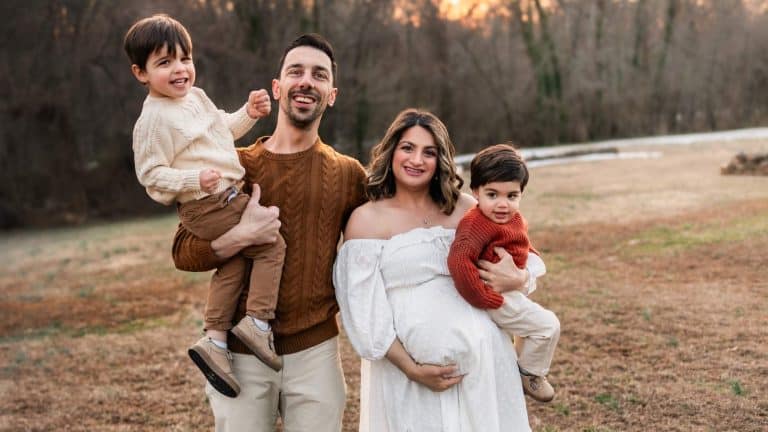 Happy family outdoor portrait with children and parents in a park setting.